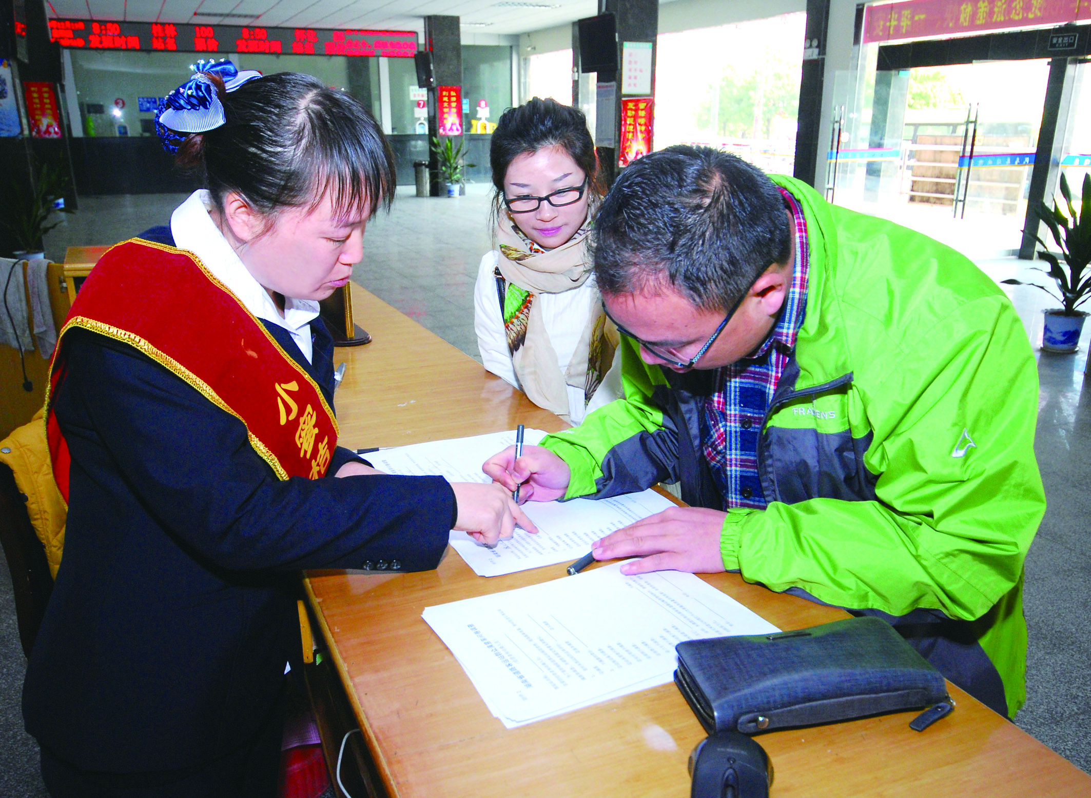 圖為洞口汽車總站站務(wù)人員在熱心為旅客服務(wù)。