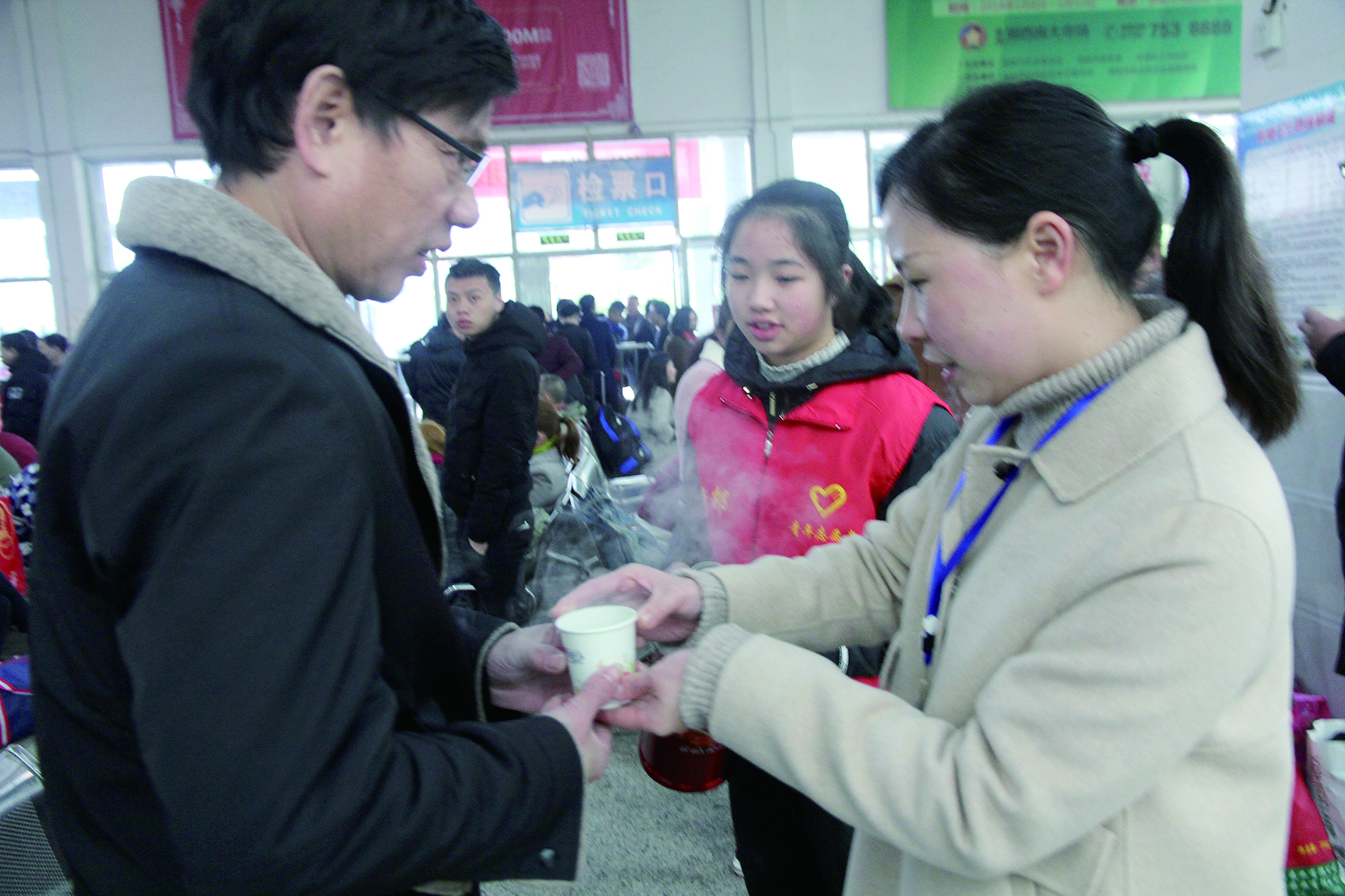 母女服務(wù)春運 2月13日，記者在新邵分公司汽車站看到，該分公司安全科副科長李喜梅與其在新邵一中初中部1701班就讀女兒劉嘉怡在車站擔(dān)當(dāng)志愿者。李喜梅在候車室耐心為旅客釋疑解惑，劉嘉怡為旅客遞上一杯杯熱茶，有時母女也相互合作，其樂融融。 祖冠 攝影報道